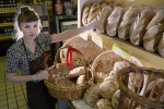 Marie, an employee at Uppercrust Bakery in Gainesville, stocks fresh bread on the shelves.